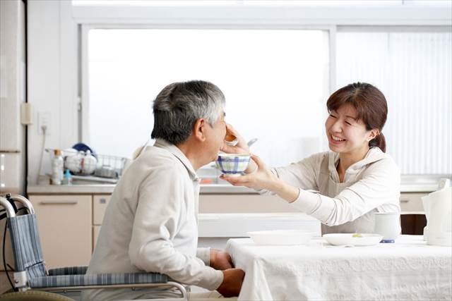 介護食を食べさせる女性